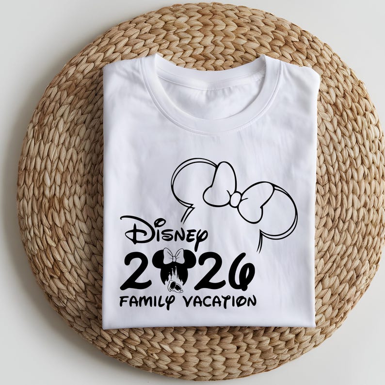May include: White t-shirt with a black graphic design featuring the Disney logo, the year "2020", and the words "Family Vacation". The design includes a Minnie Mouse bow and ears.