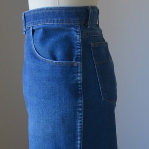 May include: Close-up of blue denim jeans. The jeans have a classic five-pocket design, with a front pocket and a back pocket visible. The denim has a medium wash, and the stitching is a contrasting colour.
