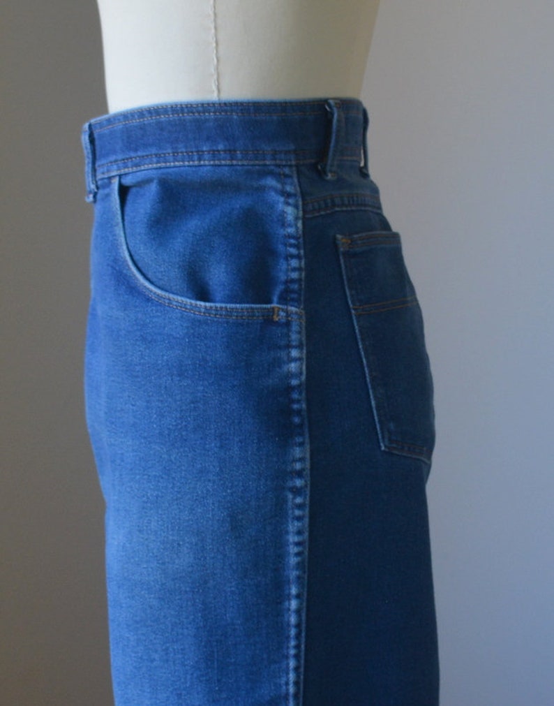 May include: Close-up of blue denim jeans. The jeans have a classic five-pocket design, with a front pocket and a back pocket visible. The denim has a medium wash, and the stitching is a contrasting colour.