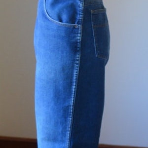 May include: Blue denim jeans with a classic five-pocket design. The jeans are displayed on a mannequin, showcasing the fit and style. The jeans have a straight leg and a medium wash.
