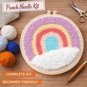 Könnte beinhalten: Ein Punch-Needle-Set mit einem Regenbogen-Design. Der Regenbogen hat rosa, rote, gelbe und blaue Farben mit einer weißen Wolke am unteren Rand. Das Set enthält Wollknäuel, eine Schere und ein Punch-Needle-Werkzeug. Der Text auf dem Bild lautet "Punch Needle Kit", "Complete Kit" und "Beginner Friendly".