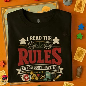 May include: Black t-shirt featuring the text "I READ THE RULES SO YOU DON'T HAVE TO" in white and red. The design incorporates dice, game pieces, and playing cards, indicating a board game theme.