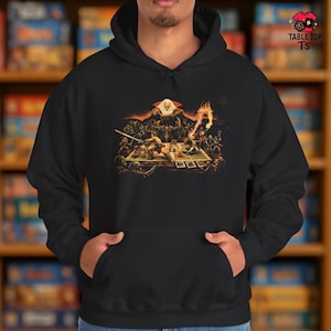 May include: Black hooded sweatshirt with a detailed graphic depicting a fantasy battle scene with figures, swords, and a wizard. The image has a vintage, illustrated style. The text "TABLE TOP TS" is printed on the upper right corner.