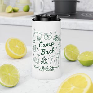 May include: White can cooler with a black top, featuring green line art and the text "Camp Bach." The design includes illustrations of a disco ball, rings, a cake, a campfire, and more. The text "Lexi's Bach Weekend LAKE TAHOE 2026" is also included.