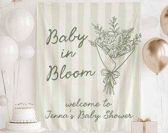 May include: A baby shower banner with the text "Baby in Bloom" in green script, accompanied by a floral bouquet illustration. The background features vertical stripes in a soft green and white. The banner also includes the text "welcome to Jenna's Baby Shower".