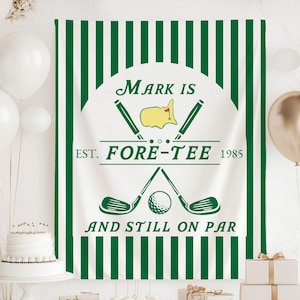 May include: A white banner with green vertical stripes and a golf-themed design. The banner features the text "Mark Is Fore-Tee 1985" and "And Still On Par" with golf clubs and a golf ball illustration. Balloons and a cake are in the background.