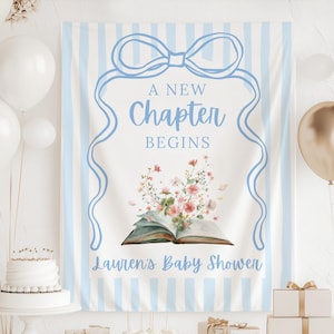 Puede incluir: Una pancarta de baby shower con un diseño de lazo y cinta azul claro. La pancarta dice "A New Chapter Begins" en escritura azul claro, con "Lauren's Baby Shower" debajo. Se presenta un libro abierto con acentos florales.