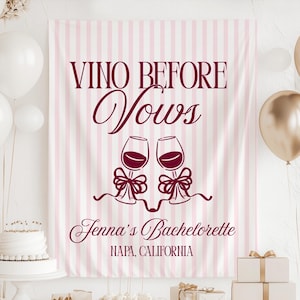 May include: A pink and white striped banner with the text "VINO BEFORE VOWS" in burgundy script. Below the text are two wine glasses with bows. The banner also includes "Jenna's Bachelorette" and "NAPA, CALIFORNIA". White and gold balloons are in the background.