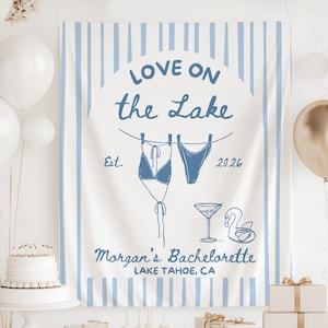 May include: A white banner with blue vertical stripes and text that reads "LOVE ON the LAKE". The banner features illustrations of a bikini, a martini glass, and a swan. The text "Morgan's Bachelorette LAKE TAHOE, CA" is also included.