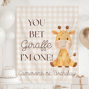 May include: A beige and white checkered backdrop with the text "YOU BET Giraffe I'M ONE!" and "Cameron's 1st Birthday". A cartoon giraffe is on the right. White and gold balloons and a cake are in the image.