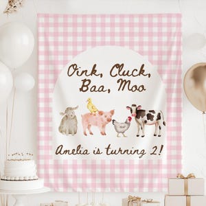 May include: A pink gingham backdrop with the text "Oink, Cluck, Baa, Moo" and "Amelia is turning 2!" features watercolor illustrations of farm animals. A sheep, duck, pig, chicken, and cow are depicted. White and gold balloons are in the background.