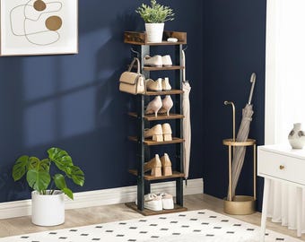 May include: A tall, multi-tiered shoe rack with a dark metal frame and wooden shelves. The rack holds various pairs of shoes, a handbag, and a small potted plant. An umbrella stand and a decorative painting are also visible.