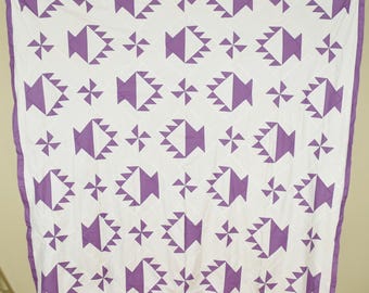 Colcha antigua vintage de los años 30 con cestas y molinillos de viento en tonos lavanda y blanco.