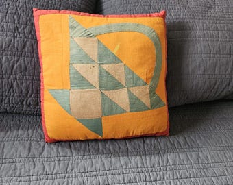 Cojín vintage con diseño de cesta en tonos rojo, verde, tostado y amarillo cheddar y naranja
