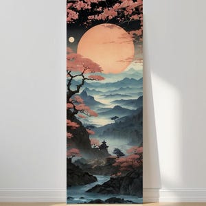 May include: A vertical art print depicting a serene landscape with a large, peach-colored moon and a smaller moon in a dark sky. Pink cherry blossoms frame the scene, with mountains and a river below. A Japanese-inspired art piece.