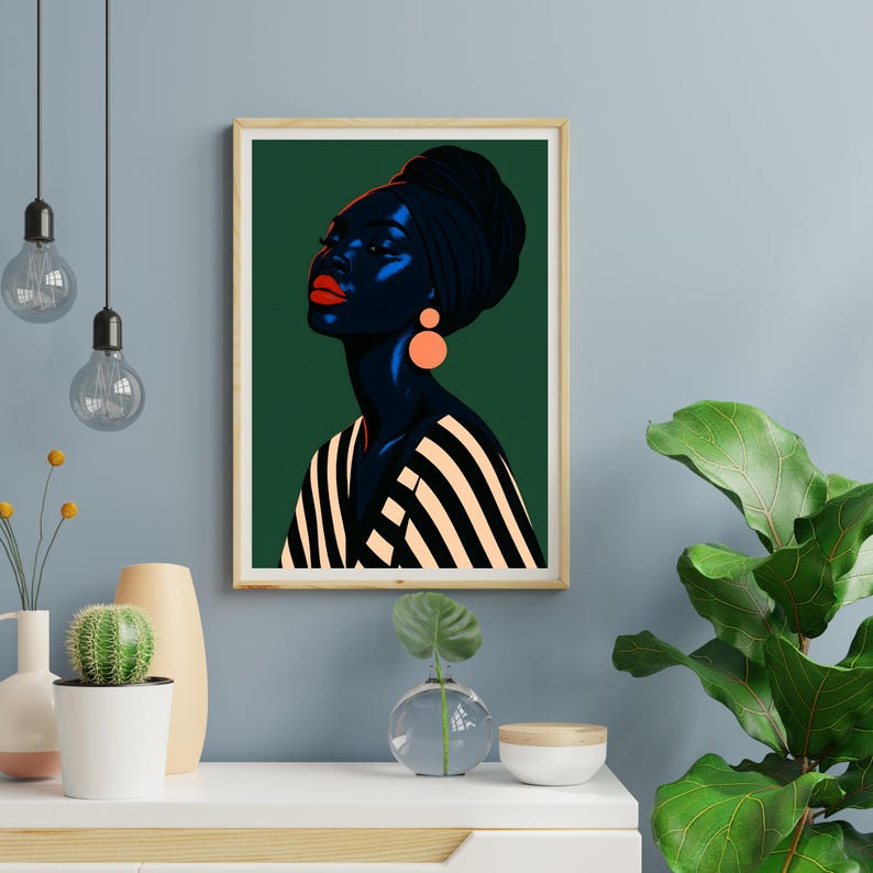May include: A framed art print featuring a stylized portrait of a person with dark skin, wearing a black head wrap and striped top. The person has red lips and orange earrings. The background is dark green.