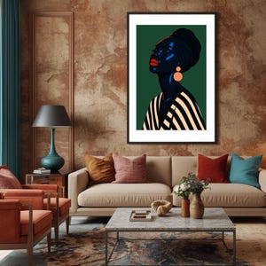May include: A framed art print featuring a stylized portrait of a woman with dark skin, wearing a black head wrap and orange earrings. The woman's lips are red, and she is wearing a black and white striped top. The background is dark green.