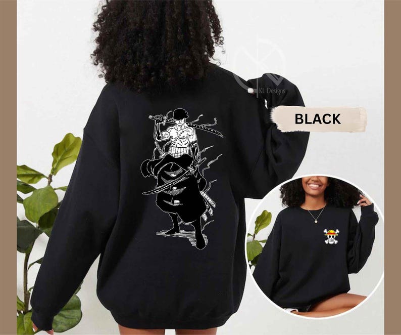 K&ouml;nnte beinhalten: Schwarzes Sweatshirt mit einer wei&szlig;en Grafik eines Charakters mit Schwertern auf dem R&uuml;cken. Das Sweatshirt hat auch eine kleine Grafik eines Totenkopfes und gekreuzten Knochen auf der Vorderseite. Das Wort "BLACK" wird auf dem Bild angezeigt.