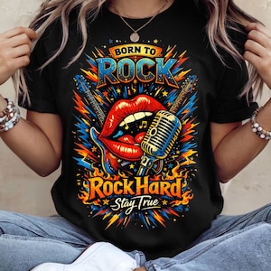 Könnte beinhalten: Schwarzes T-Shirt mit einem farbenfrohen Grafikdesign. Das Design zeigt die Worte "Born to Rock" und "Rock Hard Stay True" mit Gitarren, einem Mikrofon und roten Lippen. Das Design ist in Blau-, Orange- und Gelbtönen gehalten.