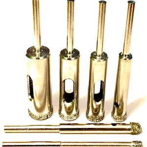 May include: Set of four silver diamond drill bits with a silver extension rod. The drill bits are different sizes and have a diamond-tipped cutting edge.