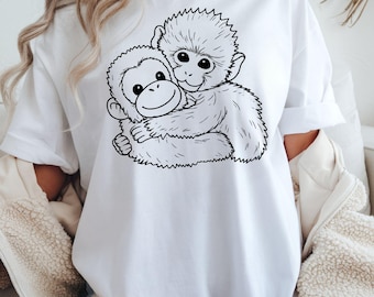 May include: White t-shirt with a black and white illustration of two monkeys embracing. The design depicts one monkey hugging another, with detailed line art creating a playful image. The shirt is made of a soft, comfortable material, suitable for casual wear.