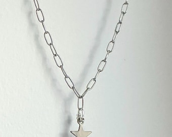 May include: A silver-colored necklace with a chain link design. The necklace features a star-shaped pendant hanging from the center. The chain is made of oval links. The star pendant is smooth and has a five-point design.