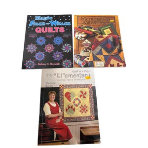 May include: Three instructional quilting books. The top left book is titled Magic Stack-n-Whack Quilts by Bethany S. Reynolds. The top right book is Memories & Milestones by Debbie Mumm. The bottom book is It's El-ementary by Eleanor Burns.
