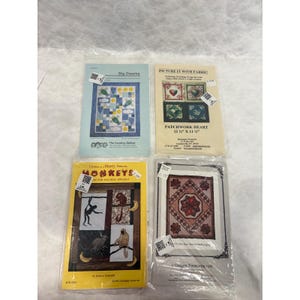 May include: Four packaged quilting patterns. Titles include "Sky Dreams", "Picture It With Fabric", "Monkeys", and "Patchwork Heart". The "Monkeys" pattern is yellow with monkey illustrations. The "Patchwork Heart" pattern is 29.2 cm x 29.2 cm.