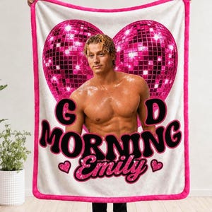 May include: A white rectangular fleece blanket with a bright pink border featuring a large pink glittery heart-shaped disco ball graphic behind a shirtless man. The text reads G D MORNING Emily in bold black and pink glittery lettering with hearts.