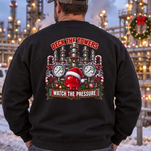 May include: A black long-sleeve sweatshirt featuring a graphic on the back of industrial refinery towers decorated with Christmas ornaments, a red hard hat with a Santa hat, and pressure gauges. The text reads DECK THE TOWERS WATCH THE PRESSURE.