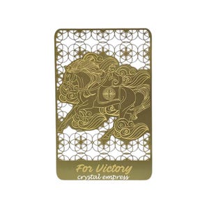 Puede incluir: Marcapáginas de metal dorado con un diseño recortado de un caballo. El caballo se representa en una pose corriendo con melena y cola fluidas. El marcapáginas tiene el texto "For Victory crystal empress" en la parte inferior.