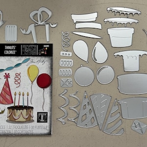May include: A collection of metal die cuts for crafting, featuring birthday-themed shapes like balloons, a cake, party hats, and gift boxes. The set includes a Sizzix Thinlits Colorize die set with 32 dies.