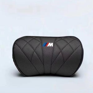 以下が含まれることがあります： キルティング模様と青、赤、白のBMW Mロゴが入った濃いグレーの車のヘッドレスト。 ヘッドレストは穴あき素材でできており、首をサポートする湾曲した形状をしています。