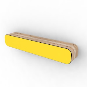 May include: A rectangular wooden bench with a bright yellow front panel and rounded corners. The bench has a natural wood grain top and sides, with a thin black border separating the yellow panel. The design is modern and minimalist.
