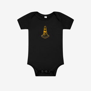 May include: A black short-sleeve baby bodysuit featuring a centered graphic of an orange and black traffic cone. The cone has the text HOIST THE CONE printed in black letters on its side. The garment has a round neckline and snap closures.