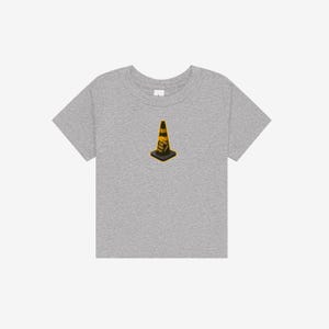 K&ouml;nnte beinhalten: Ein graues, meliertes Kurzarm-T-Shirt mit einer mittigen Grafik eines gelb-schwarzen Verkehrskegels. Der Kegel tr&auml;gt den schwarzen Schriftzug "TRUST THE CONE" an der Seite. Das T-Shirt hat einen Rundhalsausschnitt und eine normale Passform.