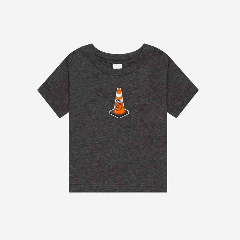 K&ouml;nnte beinhalten: Ein anthrazitfarbenes Kurzarm-T-Shirt mit einer kleinen Grafik eines orangefarbenen Verkehrskegels, der mittig auf der Brust platziert ist. Der Verkehrskegel hat einen wei&szlig;en Reflexstreifen und ein kleines rechteckiges Etikett mit dem Text HOIST THE CONE.