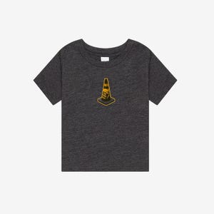 K&ouml;nnte beinhalten: Ein dunkel anthrazitfarbenes Kurzarm-T-Shirt mit einer kleinen, zentrierten Grafik eines gelb-schwarzen Verkehrskegels. Die Kegelgrafik enth&auml;lt den Text "TRUST THE CONE", der in kleinen, gut lesbaren Buchstaben auf der Vorderseite aufgedruckt ist.
