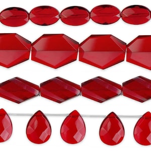 May include: Four horizontal strands of faceted red glass beads. The top row features oval beads, the second row has hexagonal beads, the third row displays diamond-shaped beads, and the bottom row consists of teardrop-shaped beads.
