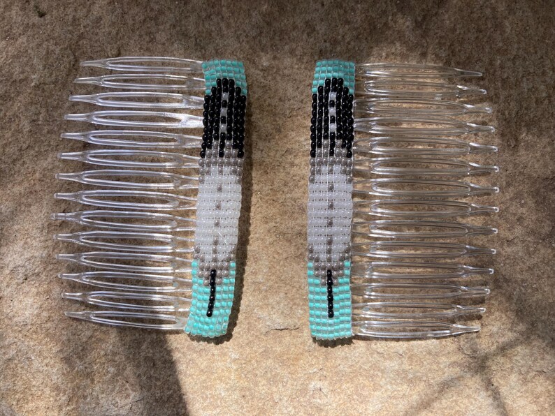 May include: Two turquoise and white beaded hair combs with a feather design. The combs are made of clear plastic.