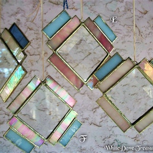 May include: Four diamond-shaped stained glass suncatchers with iridescent glass and gold trim. The suncatchers are hanging from strings and are labeled with the letters D, E, F, and G.