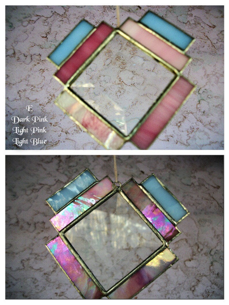 May include: A stained glass window hanging with a diamond shape. The window is made of clear glass with a border of pink and light blue glass.