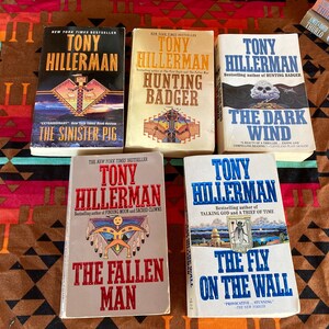 Pode incluir: Cinco livros de capa dura de Tony Hillerman s&atilde;o exibidos. Os t&iacute;tulos incluem "The Sinister Pig", "Hunting Badger", "The Dark Wind", "The Fallen Man" e "The Fly on the Wall". Os livros t&ecirc;m capas coloridas com ilustra&ccedil;&otilde;es.