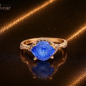 Ring met een blauwe duivelsoog-edelsteen van 0,75 karaat, geslepen volgens laboratoriumtechniek, en een roségouden verlovingsring.