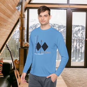 May include: A light blue long-sleeved top with a ski slope diamond symbol and the text "I'm Difficult". The graphic includes skis and poles. The shirt is made of a soft, comfortable material.