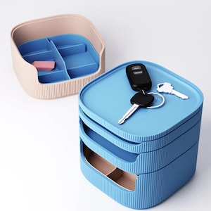 May include: Two-piece storage set. One is a light pink and blue organizer with compartments. The other is a three-tiered blue storage box with keys on top. Both have a ribbed texture.