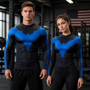 May include: A long-sleeve compression shirt featuring a blue and black color scheme with a stylized bird emblem on the chest. The garment has a mock neck, fitted sleeves, and a geometric pattern across the torso, designed for athletic performance.