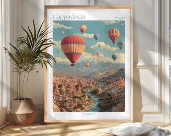May include: A framed print of Cappadocia, Turkey, featuring hot air balloons in a vibrant sky. The artwork showcases a scenic landscape with a river, town, and mountains. The print is in a wooden frame.