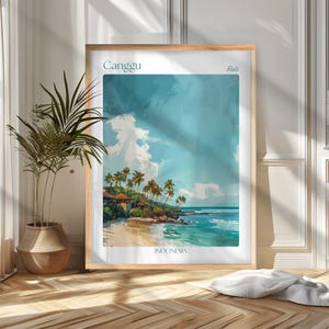 Puede incluir: Una impresión artística enmarcada que presenta una escena de playa tropical con el texto "Canggu Bali Indonesia". La obra de arte representa una playa de arena, palmeras y agua turquesa bajo un cielo nublado. La impresión se muestra en un marco de madera clara.