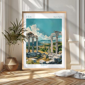 May include: A framed art print featuring a watercolor illustration of ancient ruins in Turkey. The artwork depicts weathered columns and architectural fragments under a bright blue sky with fluffy clouds. Text on the print reads "Efes", "Aegean Region", and "TURKIYE".